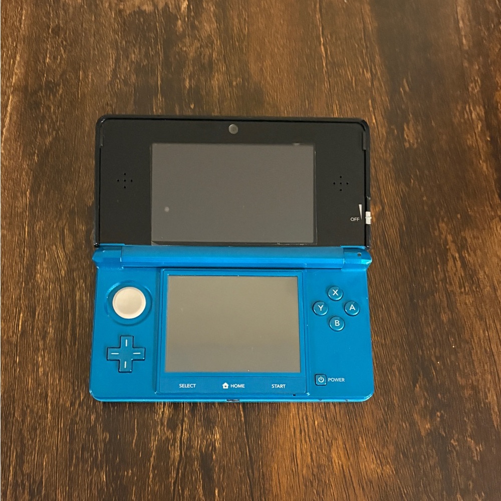Teal Nintendo 3DS with charging dock and games